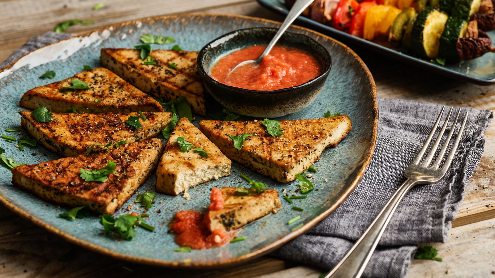 Gegrillter Tofu auf einem blauen Teller serviert
