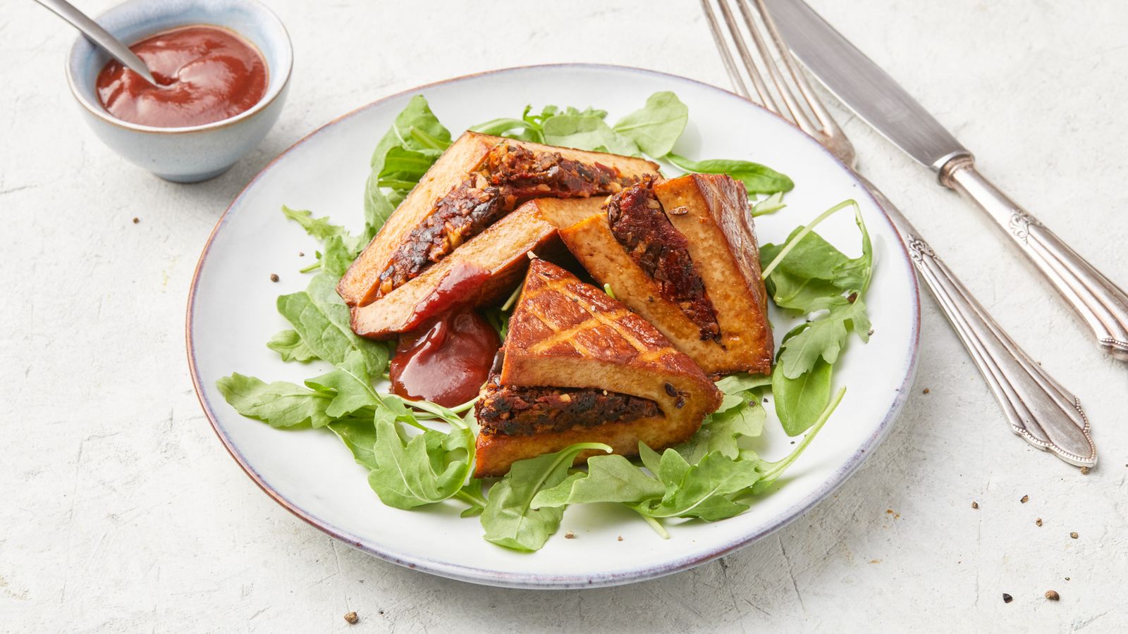 Gegrillter Tofu mit Füllung und BBQ-Sauce auf Salatblättern