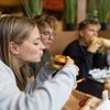 Drei Teenager-Freunde teilen sich eine ungezwungene Fast-Food-Mahlzeit im Restaurant