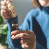 Frau entnimmt der Flasche ätherisches Öl