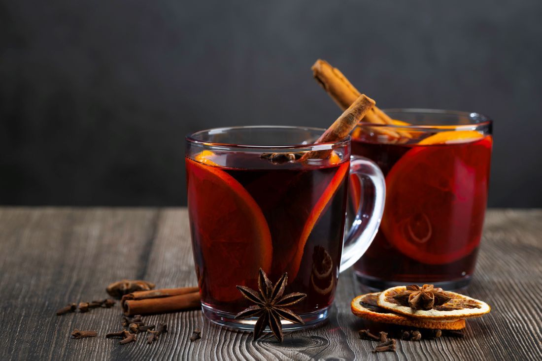 Glas Glühwein mit Orangenscheibe. Glühwein und Zutaten auf einem Holztisch
