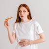 Studioporträt einer kranken, verärgerten jungen Frau, die nach dem Essen von Pizza Bauchschmerzen verspürt, Bauchschmerzen hat