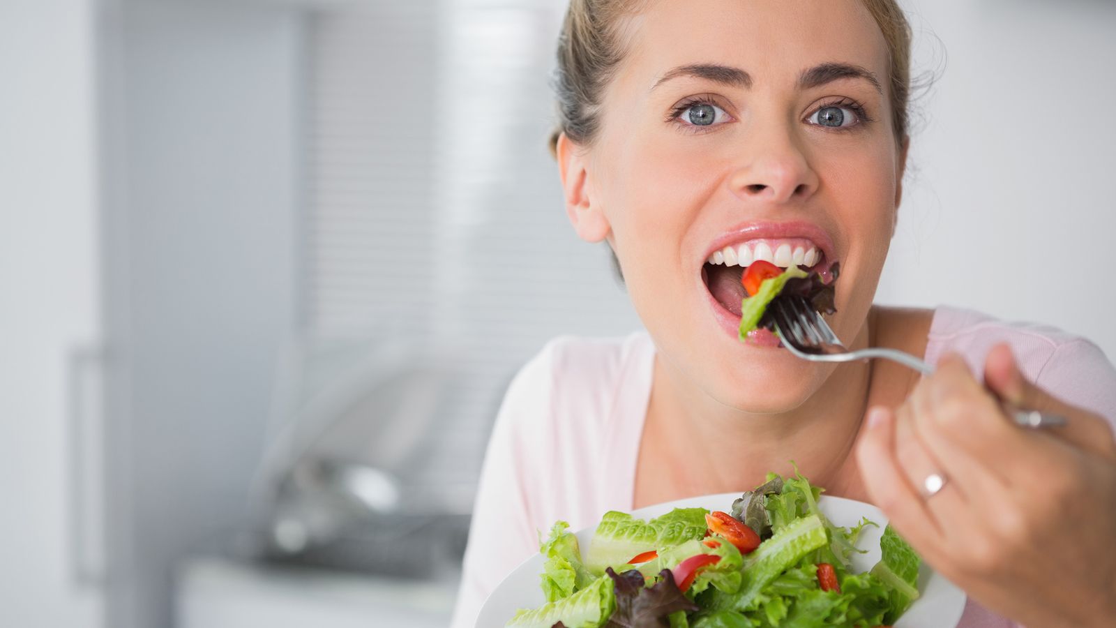 Frau isst einen grünen Salat