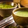 Frisch gebrühter grüner Tee in einer braunen Schale