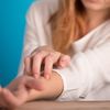 Frau mit Hauterkrankung kratzt sich am Arm