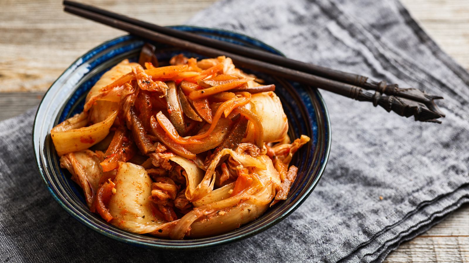Selbst gemachtes Kimchi aus Chinakohl, Karotte und Apfel in einer dunkelblauen Schüssel serviert