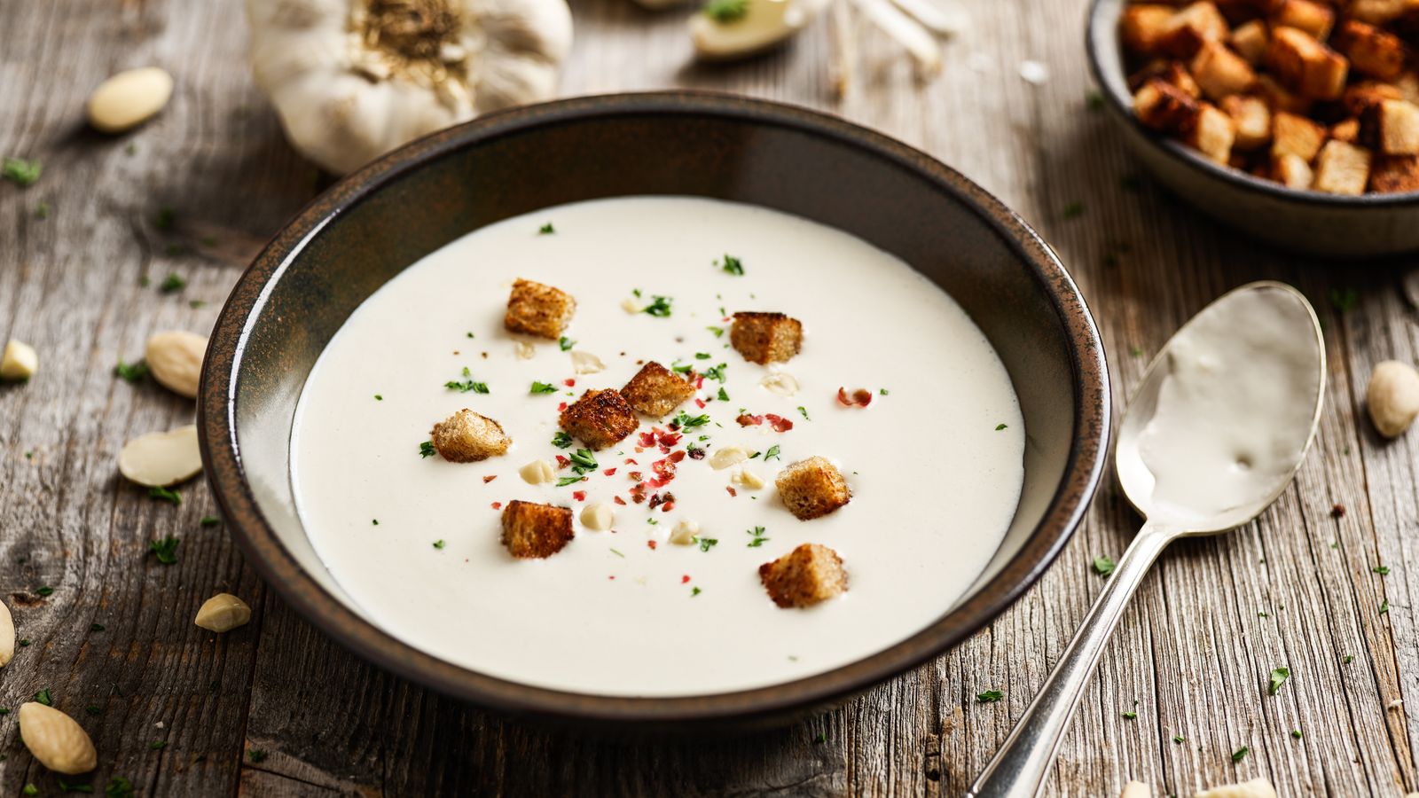 Mandel-Knoblauchsuppe in einer braunen Schale serviert