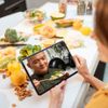 Frau hält I-pad auf dem Ben mit sdeinem Kochkurs zu sehen ist