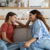 Zwei junge Frauen sitzen sich gegenüber auf dem Sofa