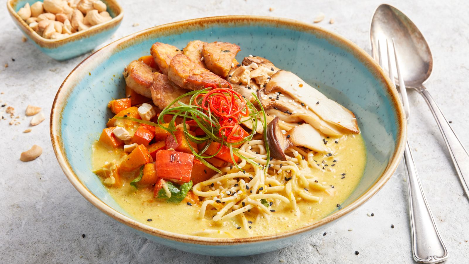 Indonesisches Kürbiscurry mit Tempeh in einer Bowl serviert