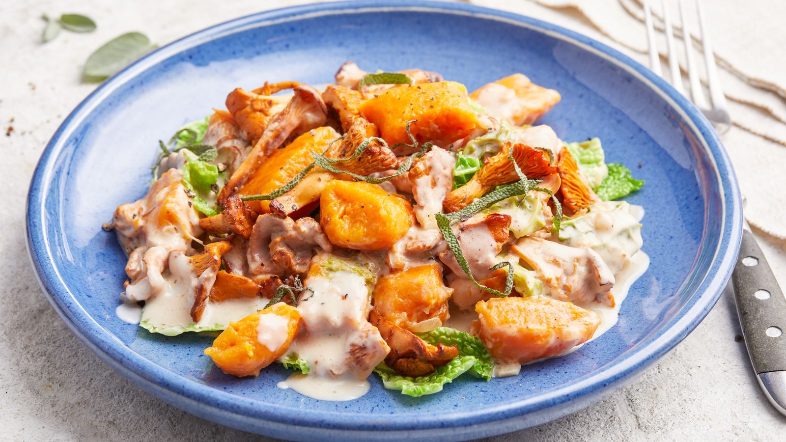 Kürbisgnocchi mit Pfifferlingen und Wirsing auf einem Teller