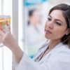 Apothekerin konzentriert sich bei der Auswahl eines verschreibungspflichtigen Medikaments aus dem Apothekenregal.
