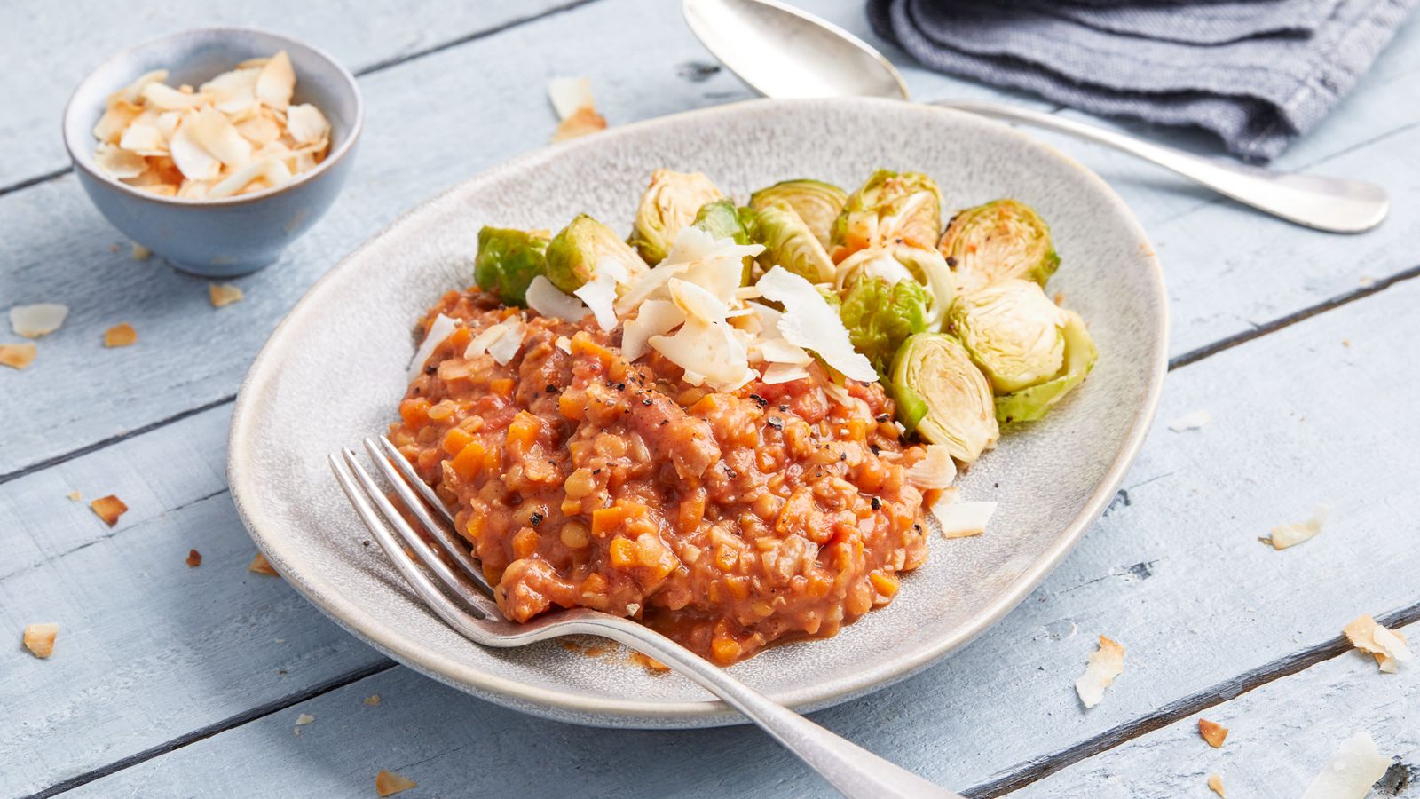 Rotes Linsen Dal mit geröstetem Rosenkohl in einem tiefen Teller angerichtet