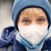 Ein Kind schützt sich mit einer Maske vor der Luftverschmutzung