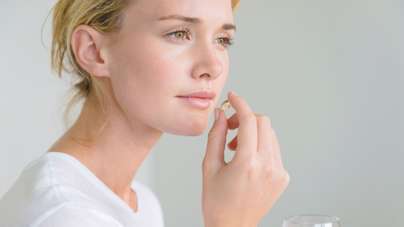 Frau nimmt eine Omega-3 Kapsel ein
