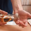 Mann massiert eine Frau mit selbstgemachtem Massageöl