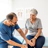 Seniorin lässt ihr Knie ärztlich untersuche