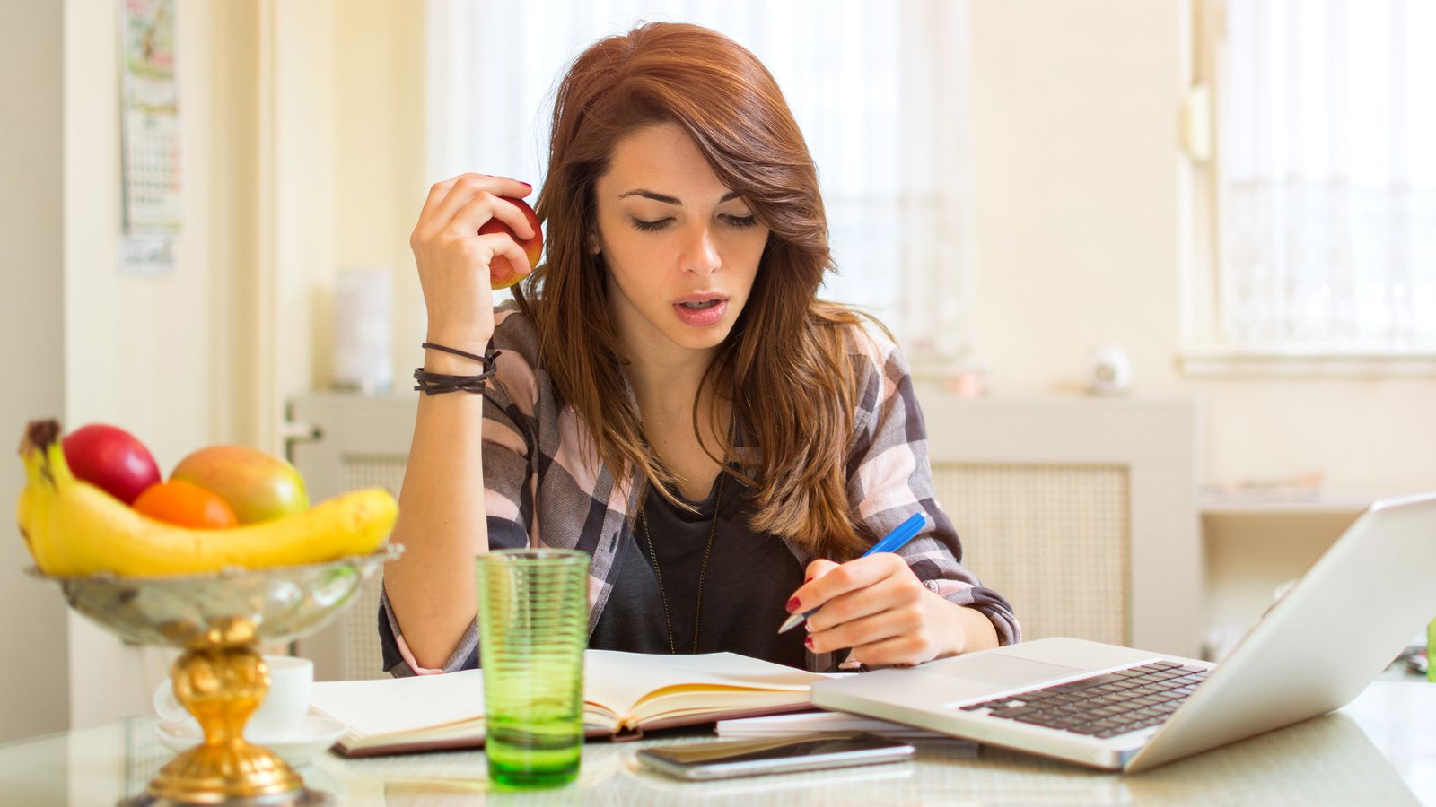 Woman is sitting in front of a laptop