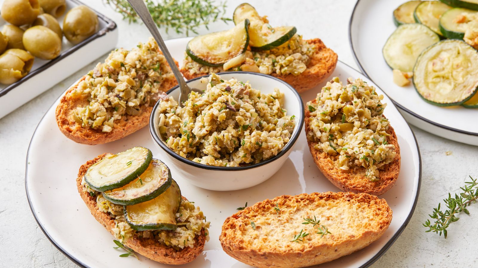 Grüne Olivenpaste mit gebratenen Zucchinischeiben und Knoblauch
