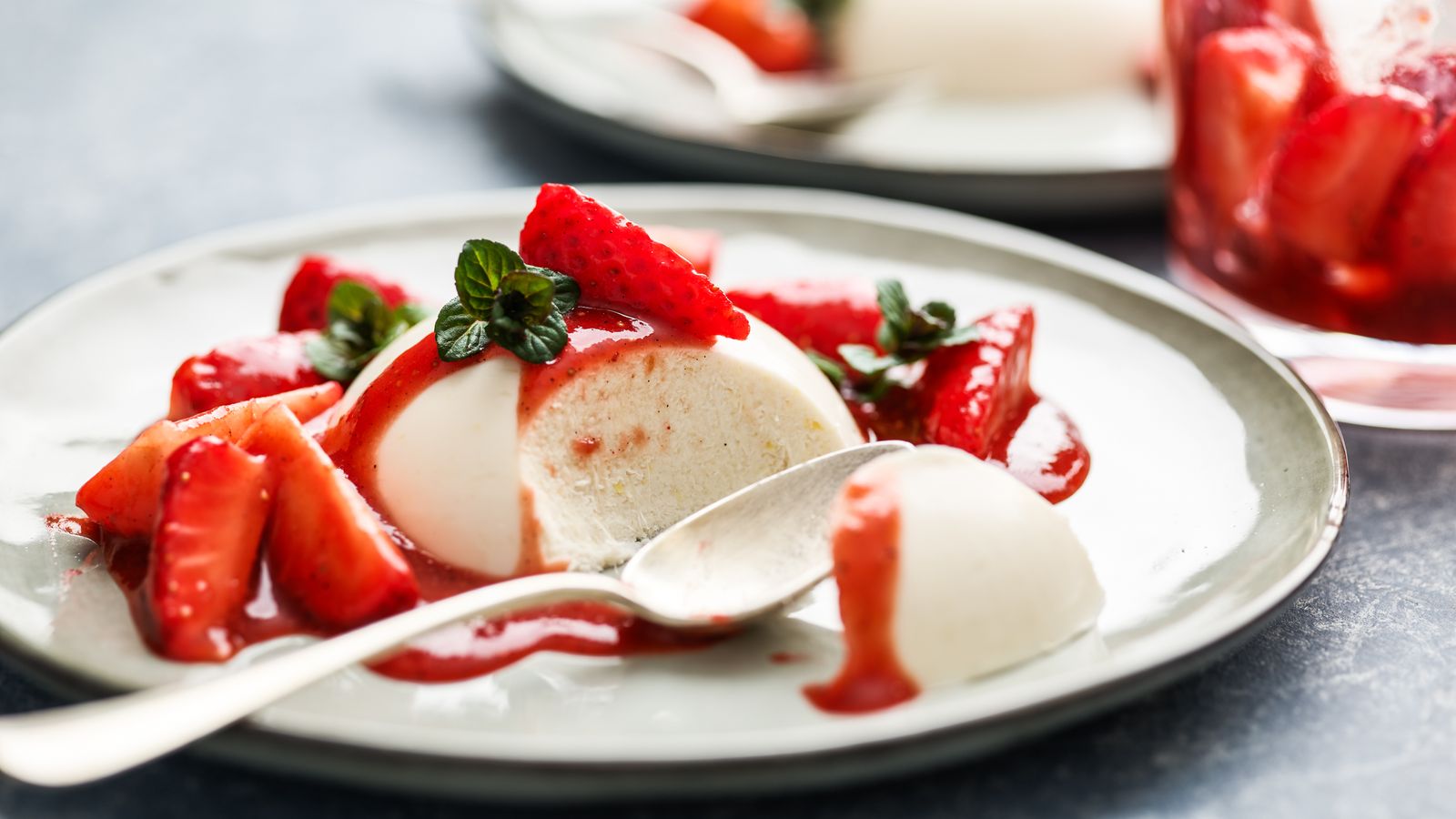 Panna Cotta mit Erdbeersalat auf einem weissen Teller serviert - vegan