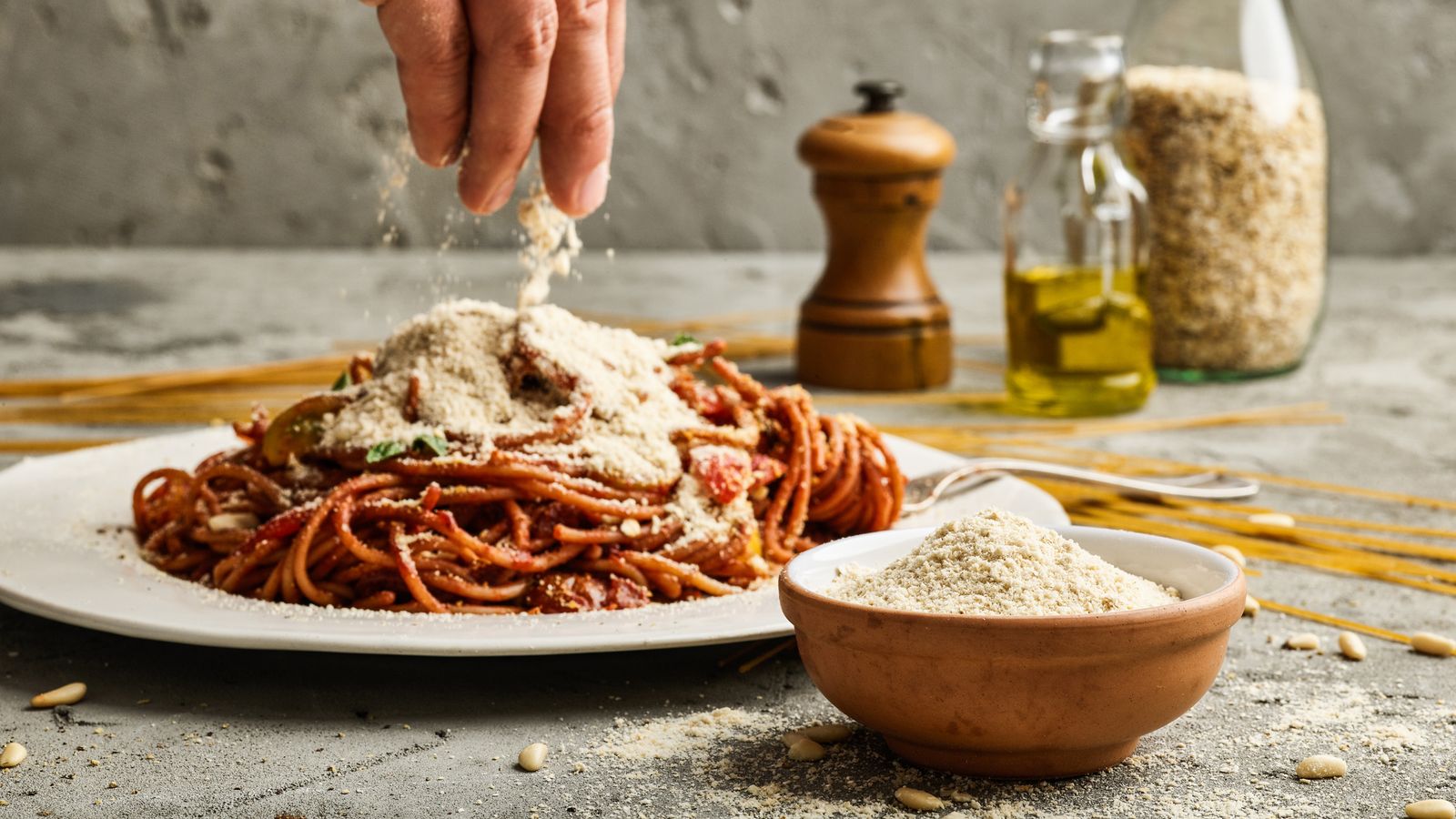 Selbst gemachter Parmesan wird über die Nudeln gestreut