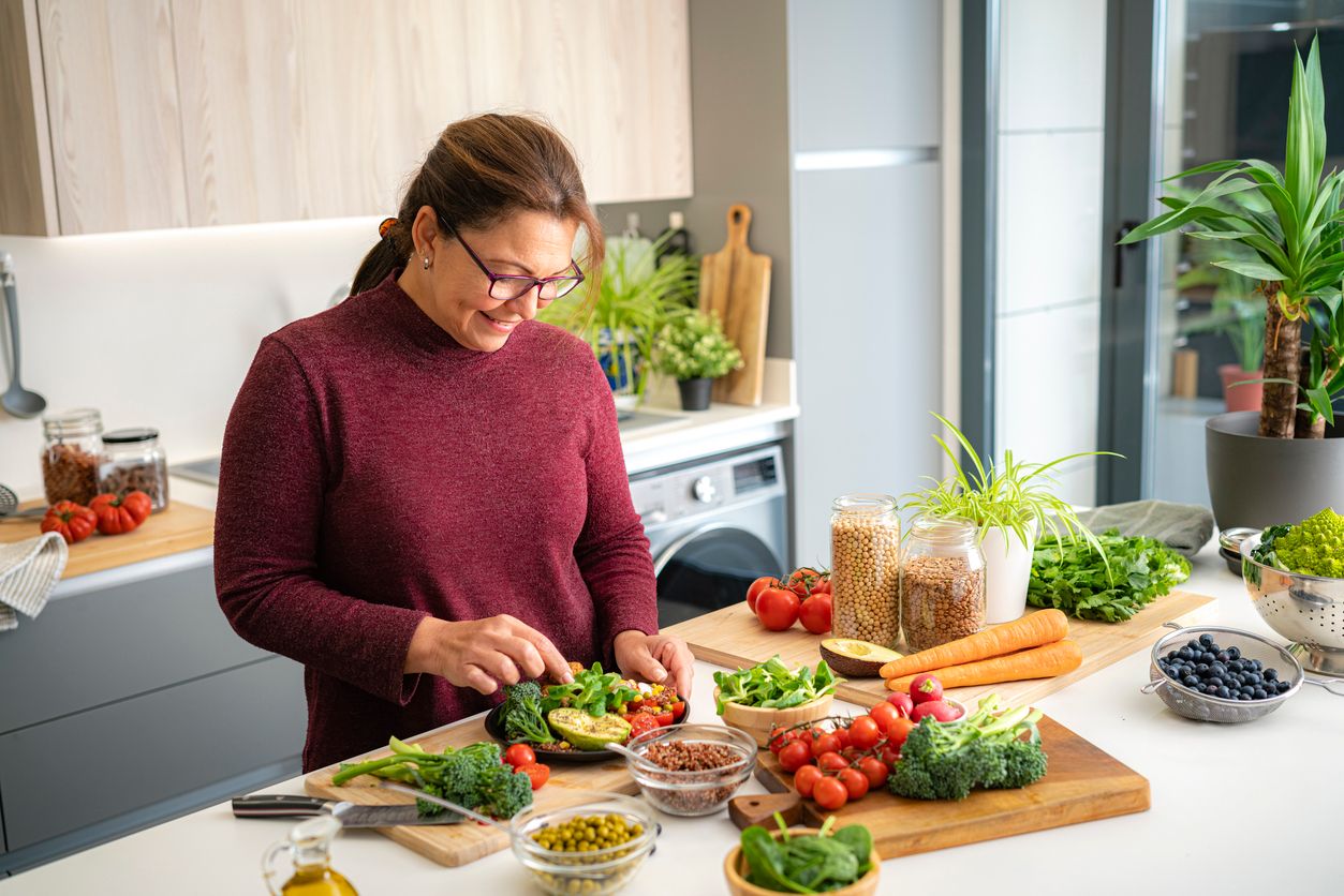 Frau, die gesunde vegane Mahlzeit zubereitet 