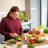 Frau, die gesunde vegane Mahlzeit zubereitet 