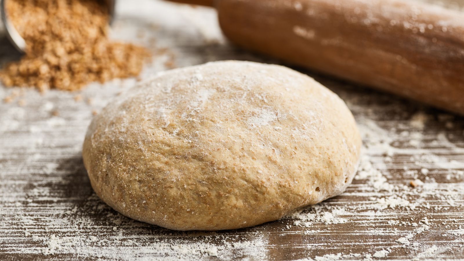 Pizzateig vorbereitet auf einem Holzbrett