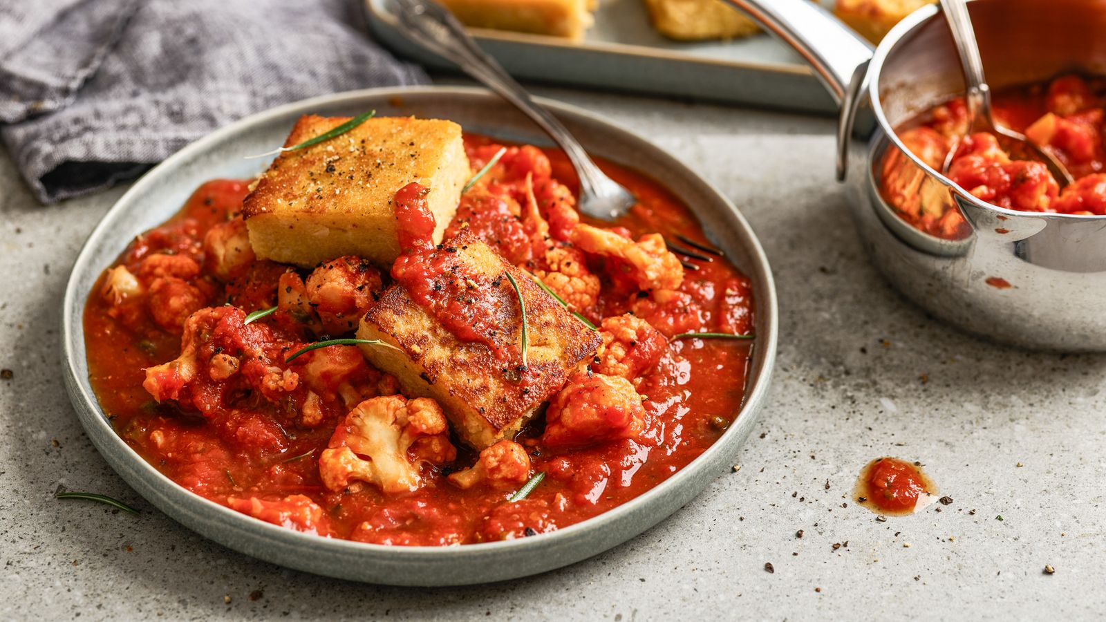 Polenta mit Blumenkohl-Tomaten-Sauce auf einem Teller