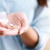 Eine Frau nimmt ein Probiotikum aus der Dose