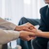 Ein Therapeut streckt einem Patienten während einer Sitzung eine tröstende Hand entgegen.
