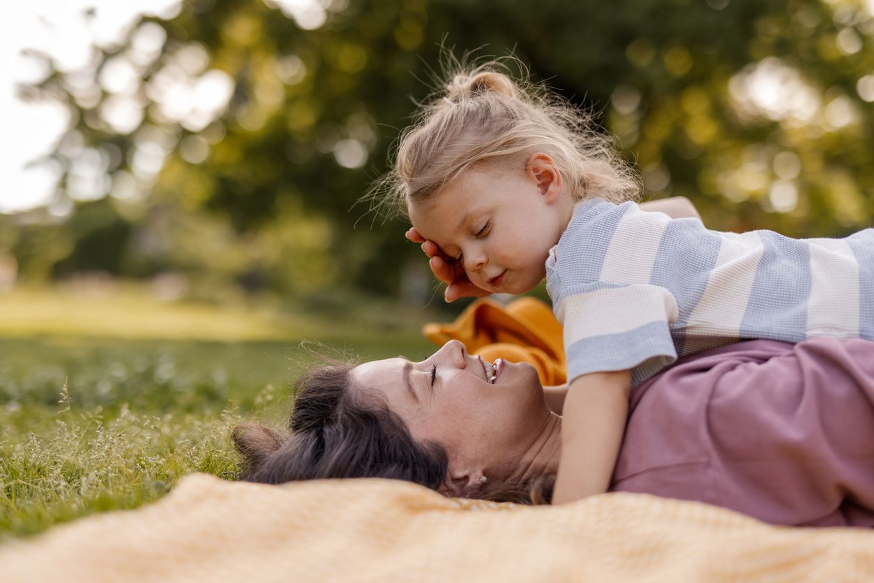 Familienspielzeit auf Picknickdecke im Sommerpark