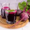 Rote Bete Saft in Gläsern augf einem Holzbrett