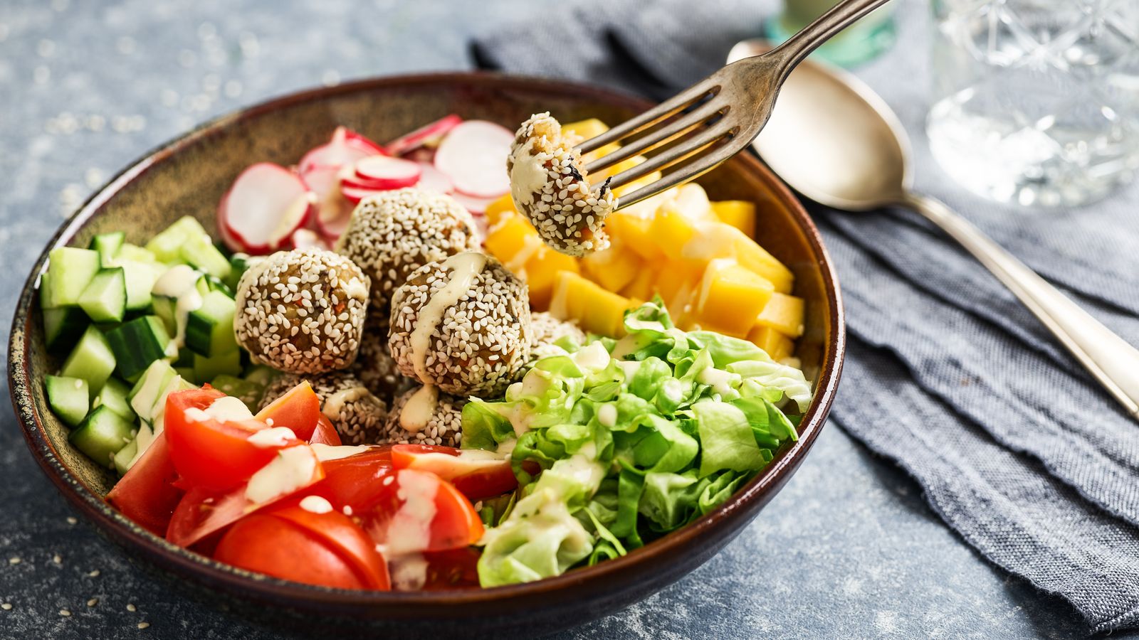 Salatbowl mit Grünkernbällchen  in einer braunen Schüssel serviert