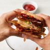 Sandwich mit Speck und Ketchup auf einem weissen Teller