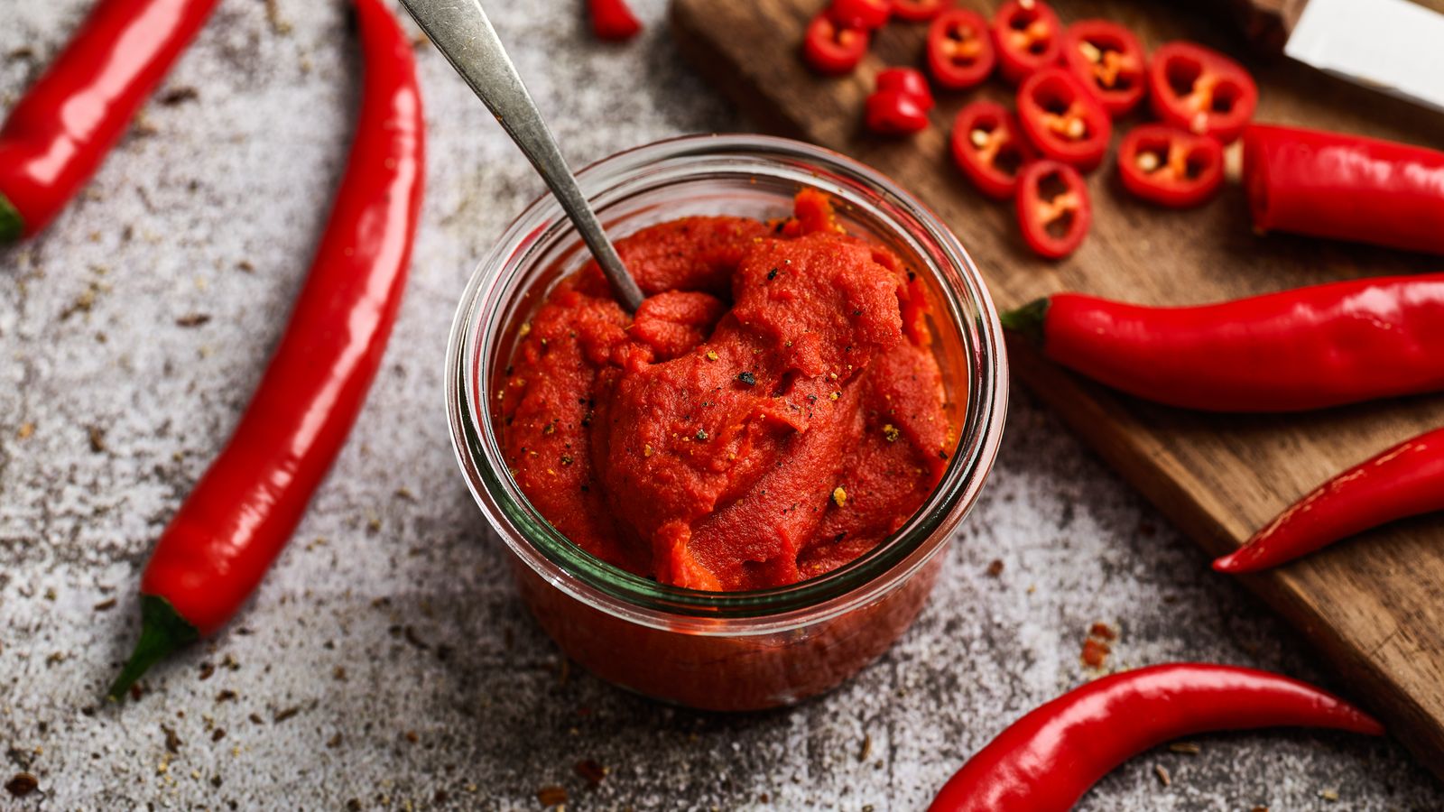 Scharfe Chilipaste mit Chili auf einem Brett