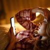 Kind nachts im Bett mit einem Handy