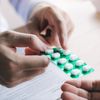 Arzt überreicht Patient Schmerzmittel