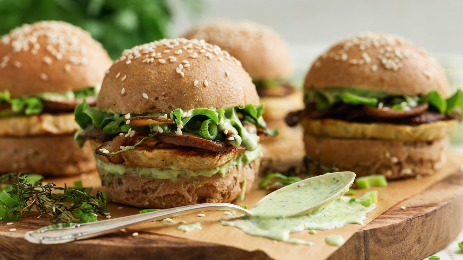 Sellerie-Burger mit Pilzen und Pesto-Mayonnaie auf einem Holzbrett serviert