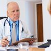 Arzt sitzt mit einer Patientin im Behandlungsraum