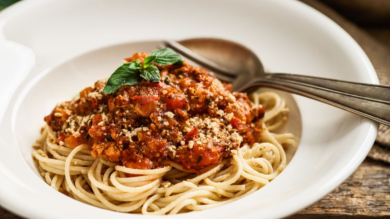 Spaghetti a la Tofu-Bolognese auf weissem Teller serviert