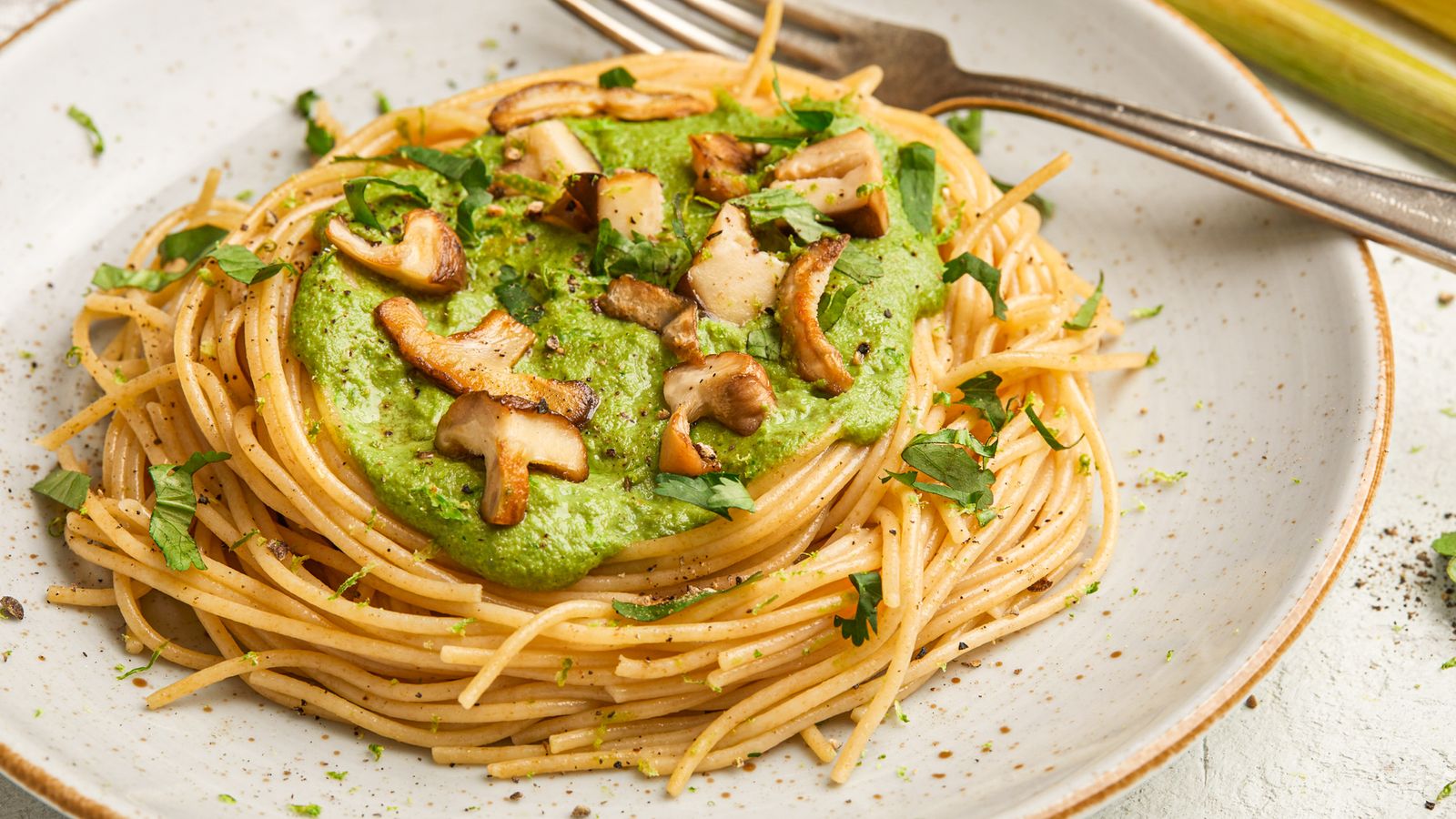 Spaghetti an einer grünen Thai-Sauce auf einem Teller