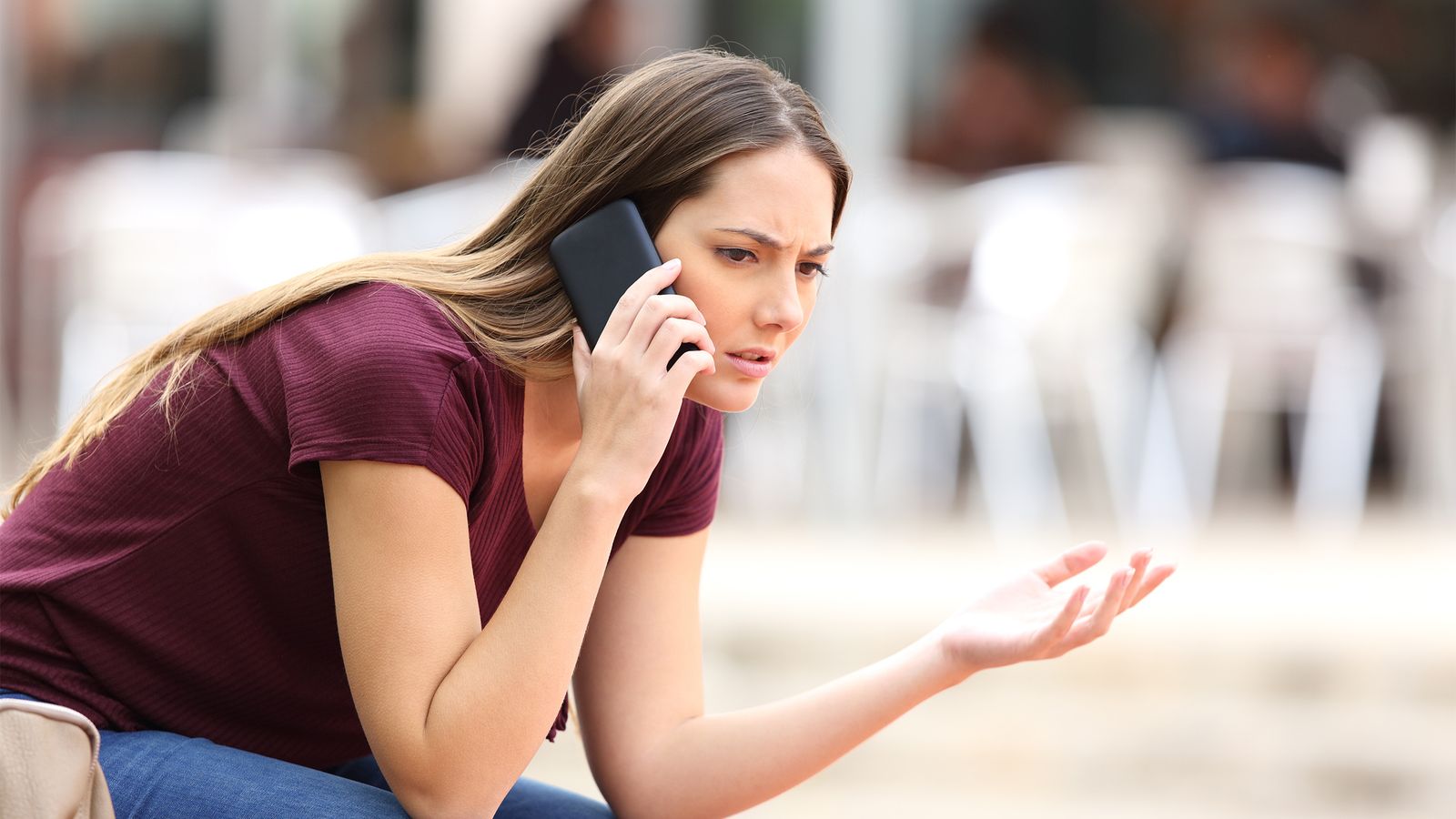 Frau telefoniert und hält das Handy am Ohr