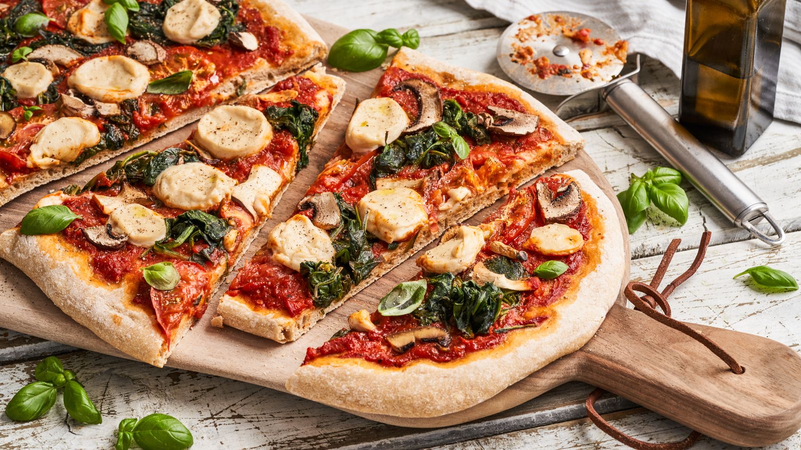 Pizza mit Spinat zugeschnitten serviert