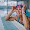 Glückliche ältere Frau im Schwimmbad, auf Kante gestütz