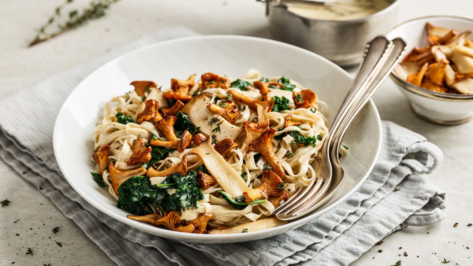 Tagliatelle mit Pfifferlingen und Grünkohl auf einem Teller