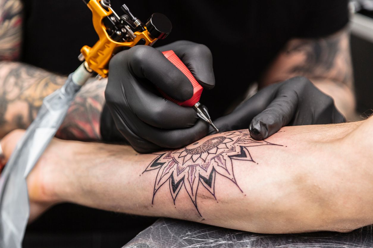 Tattoo wird an einem Arm gestochen