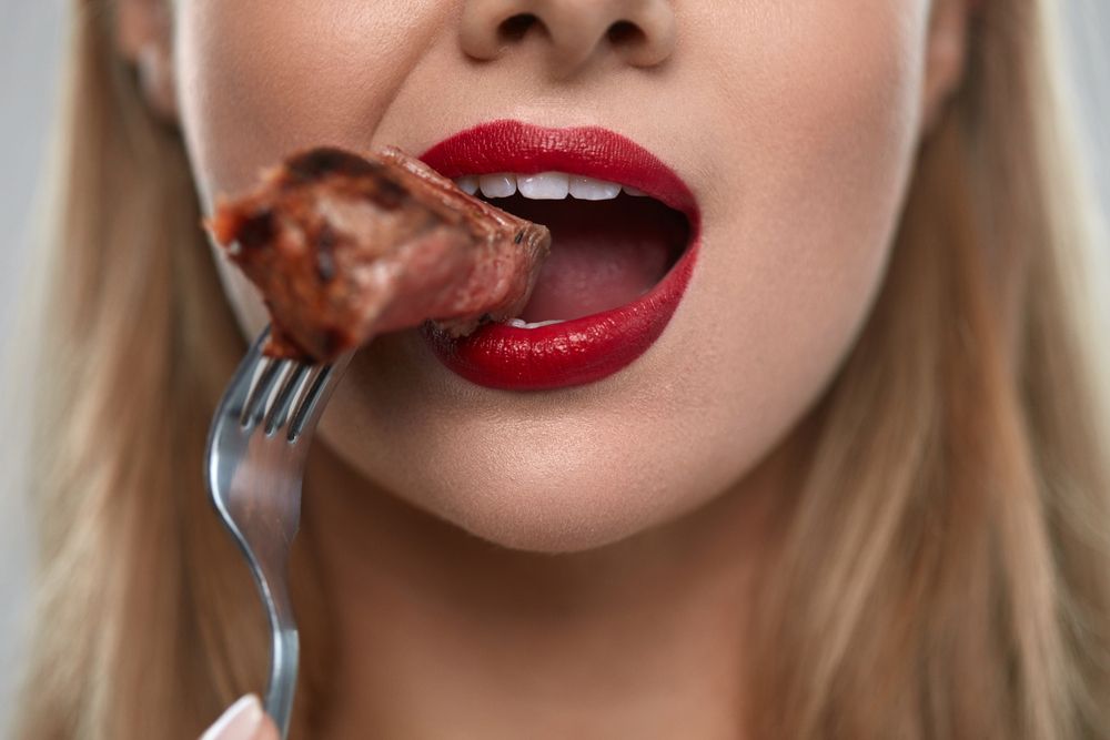 Frau isst Fleisch