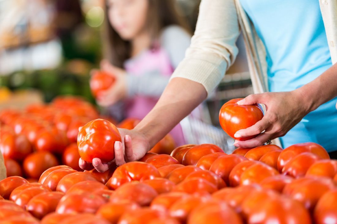 Frau kauft Tomaten auf dem Markt