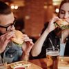 Paar isst Burger mit Pommes in einem Restaurant